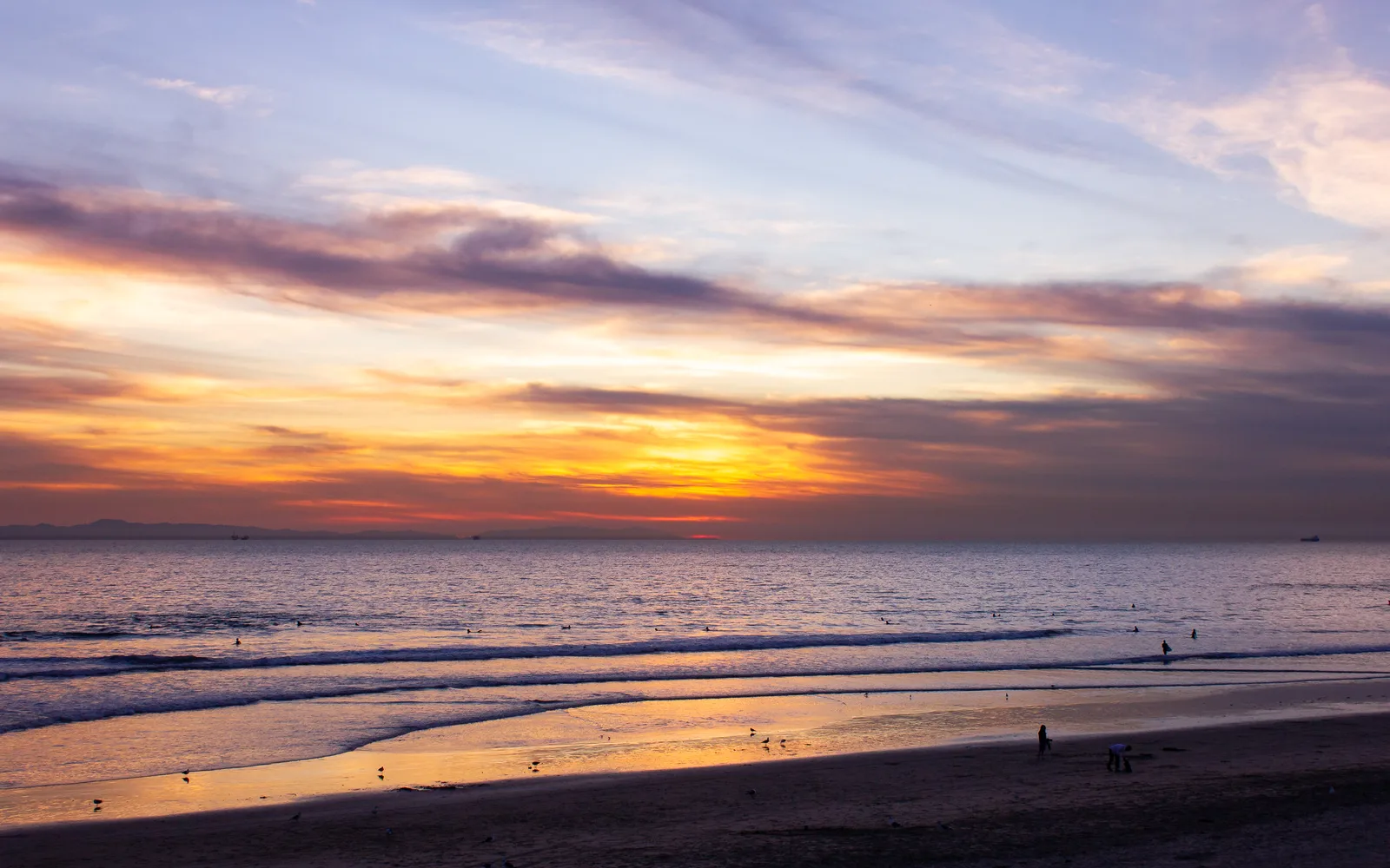 Warm golden and orange tones of a Pacific sunset at Huntington Beach